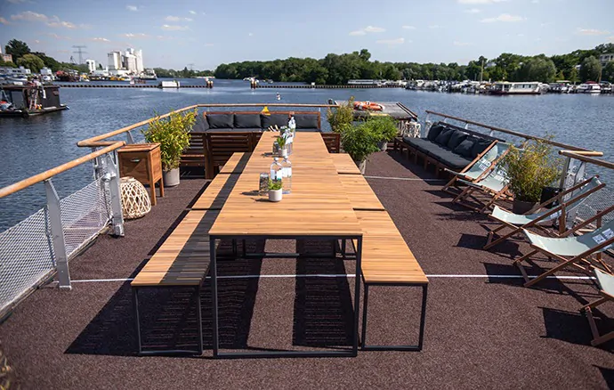 Hauptstadtfloß – Dachterrasse mit gedecktem Tisch auf dem Wasser