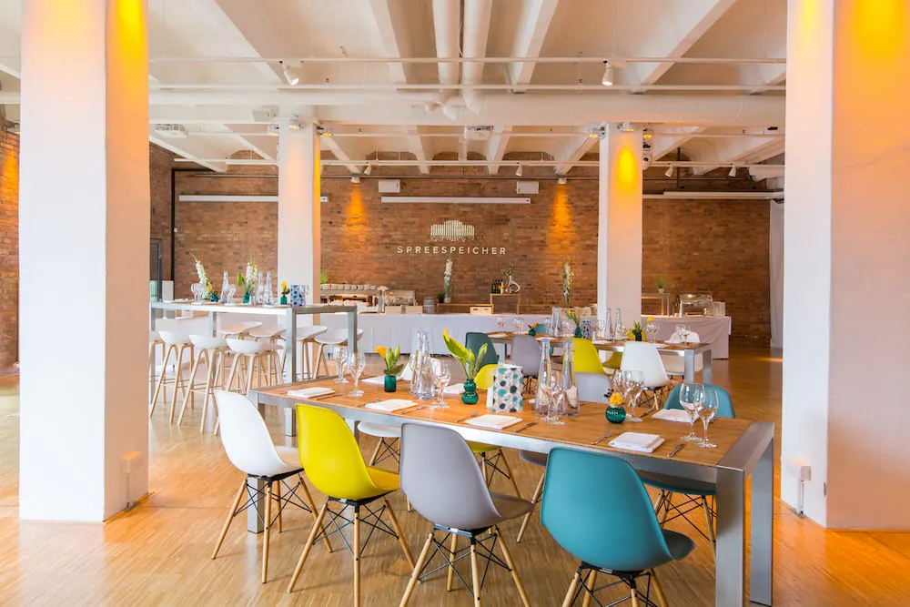 Spreespeicher Dinner-Setup mit bunten Stühlen