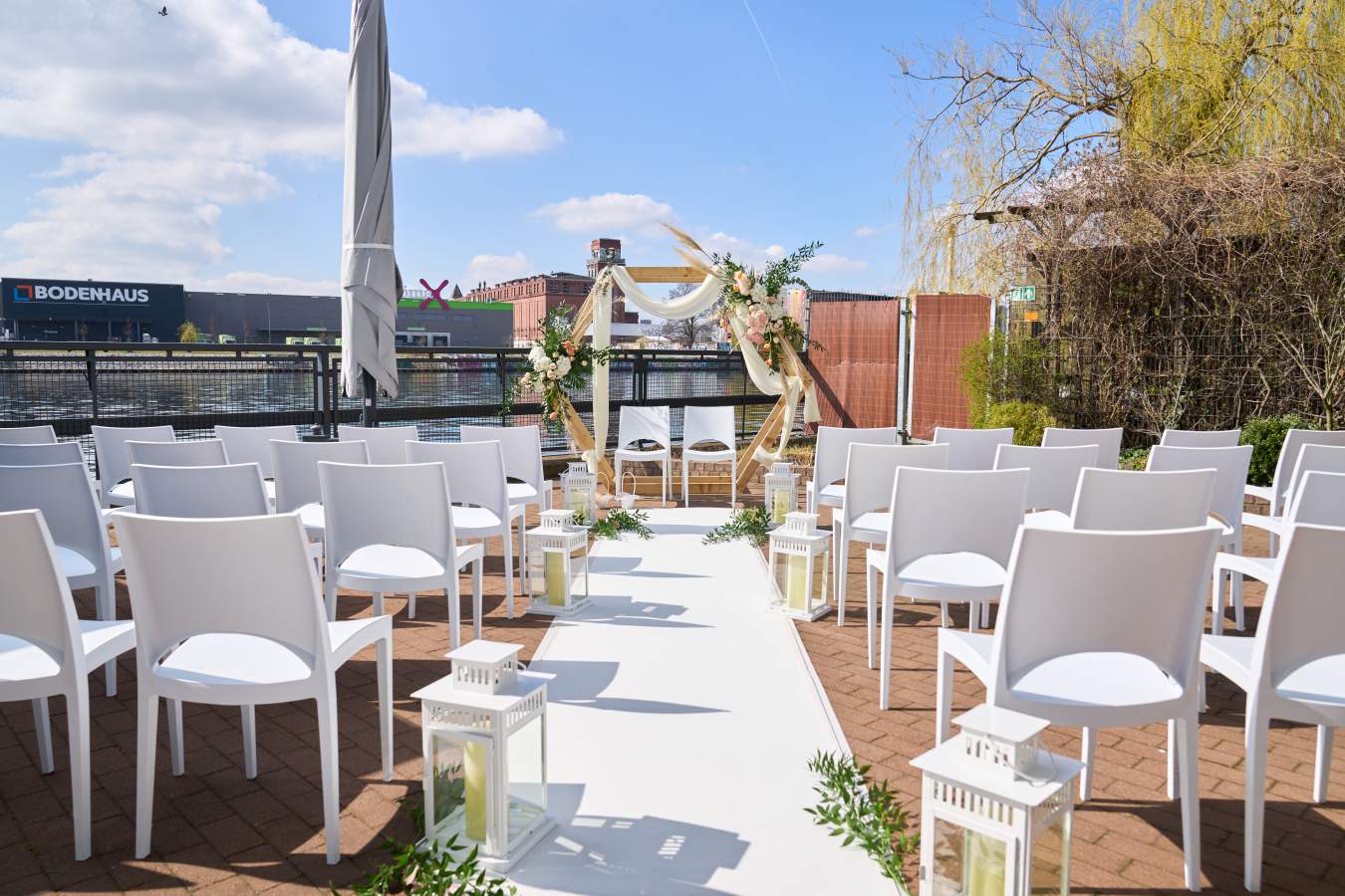 Freie Trauung an der Spree mit Bogen und weißen Stühlen (©WHITE Spreelounge)